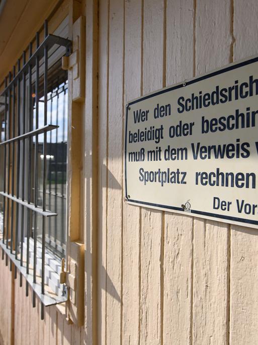 Ein Schild "Wer den Schiedsrichter beleidigt oder beschimpft, muß mit dem Verweis vom Sportplatz rechnen! Der Vorstand" hängt am Funktionsgebäude der SG Motor Trachenberge am Sportplatz Aachener Straße.