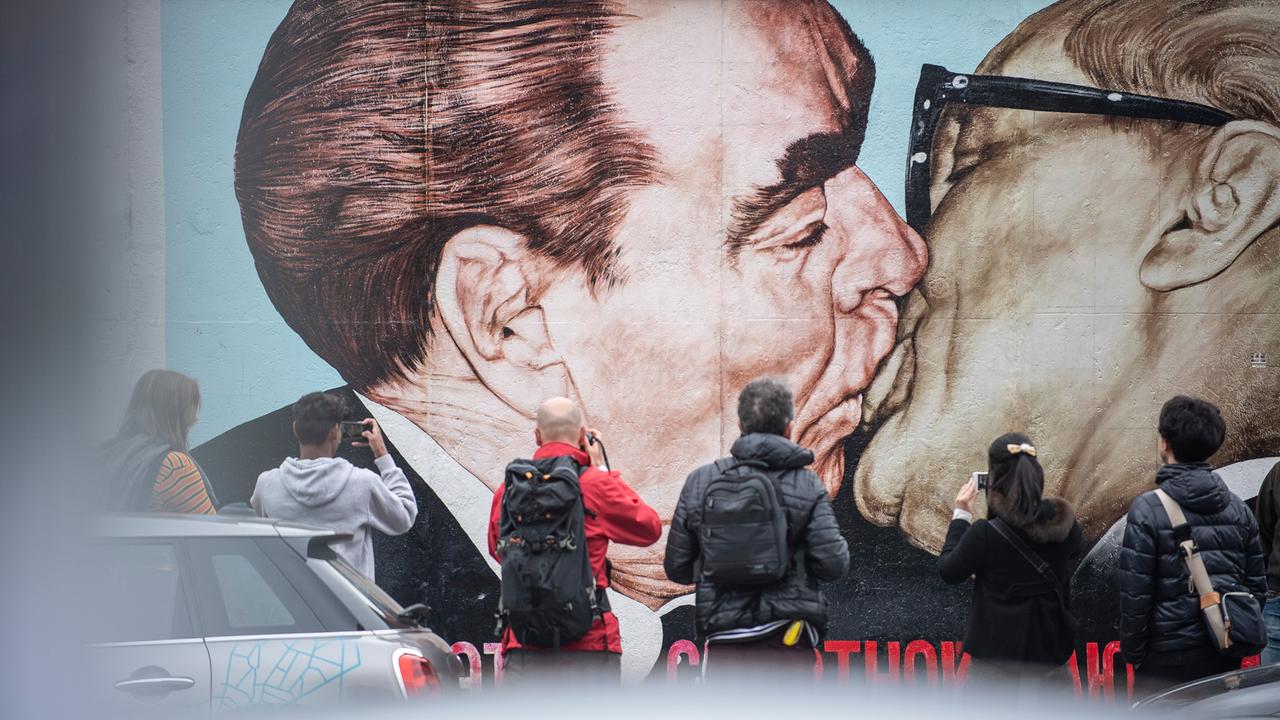 Touristen fotografieren das Bruderkuss-Graffiti an der East Side Gallery.