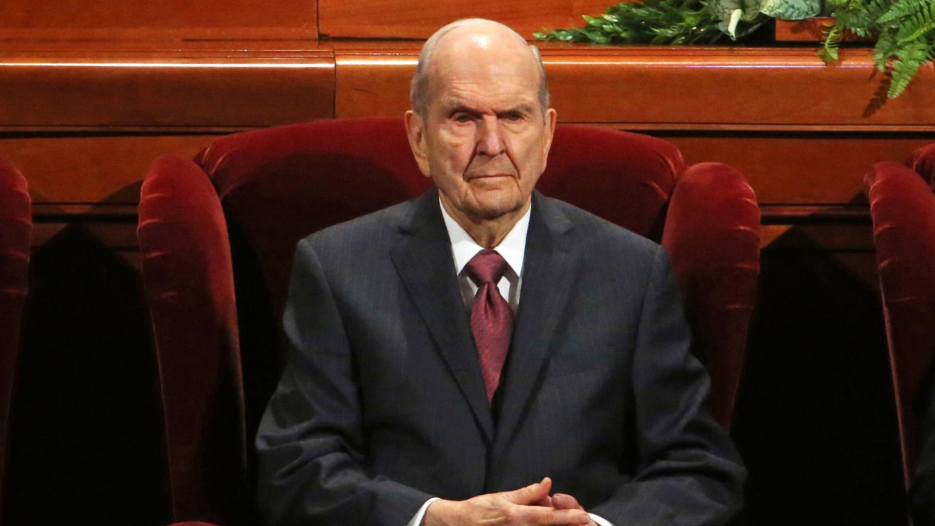 Russell Nelson sitzt in einem Sessel und schaut ernst in Richtung der Kamera. 