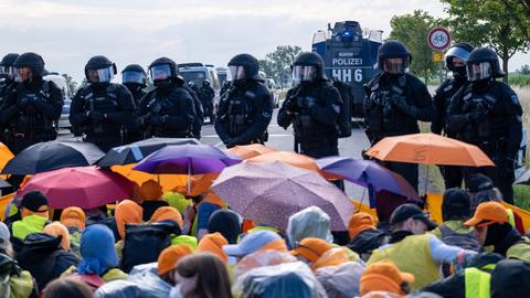 Demonstranten mit bunten Regenschirmen protestieren gegen die AfD in Erfurt. Demonstranten mit bunten Regenschirmen protestieren gegen die AfD in Erfurt.