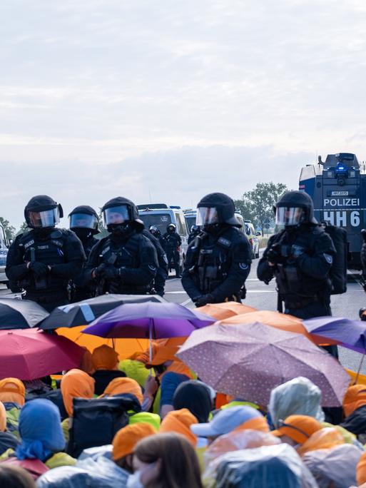 Demonstranten mit bunten Regenschirmen protestieren gegen die AfD in Erfurt. Demonstranten mit bunten Regenschirmen protestieren gegen die AfD in Erfurt.