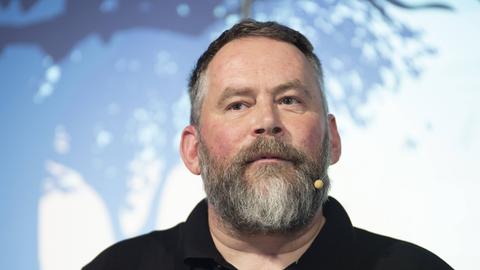 Der Medienjournalist Stefan Niggemeier hat ein Ansteckmikrofon im dichten, grauen Bart.
