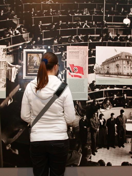 Ausstellung - Tödliche Medizin: Rassenwahn im Nationalsozialismus - im Jüdischen Museum in Berlin / Besucherin vor einem Bild, welches eine Vorlesung an der Berliner Charite zeigt
