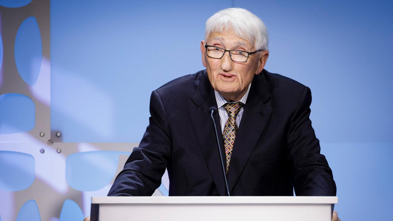 Der Soziologe und Philosoph Jürgen Habermas steht an einem Rednerpult und spricht zum Publikum.