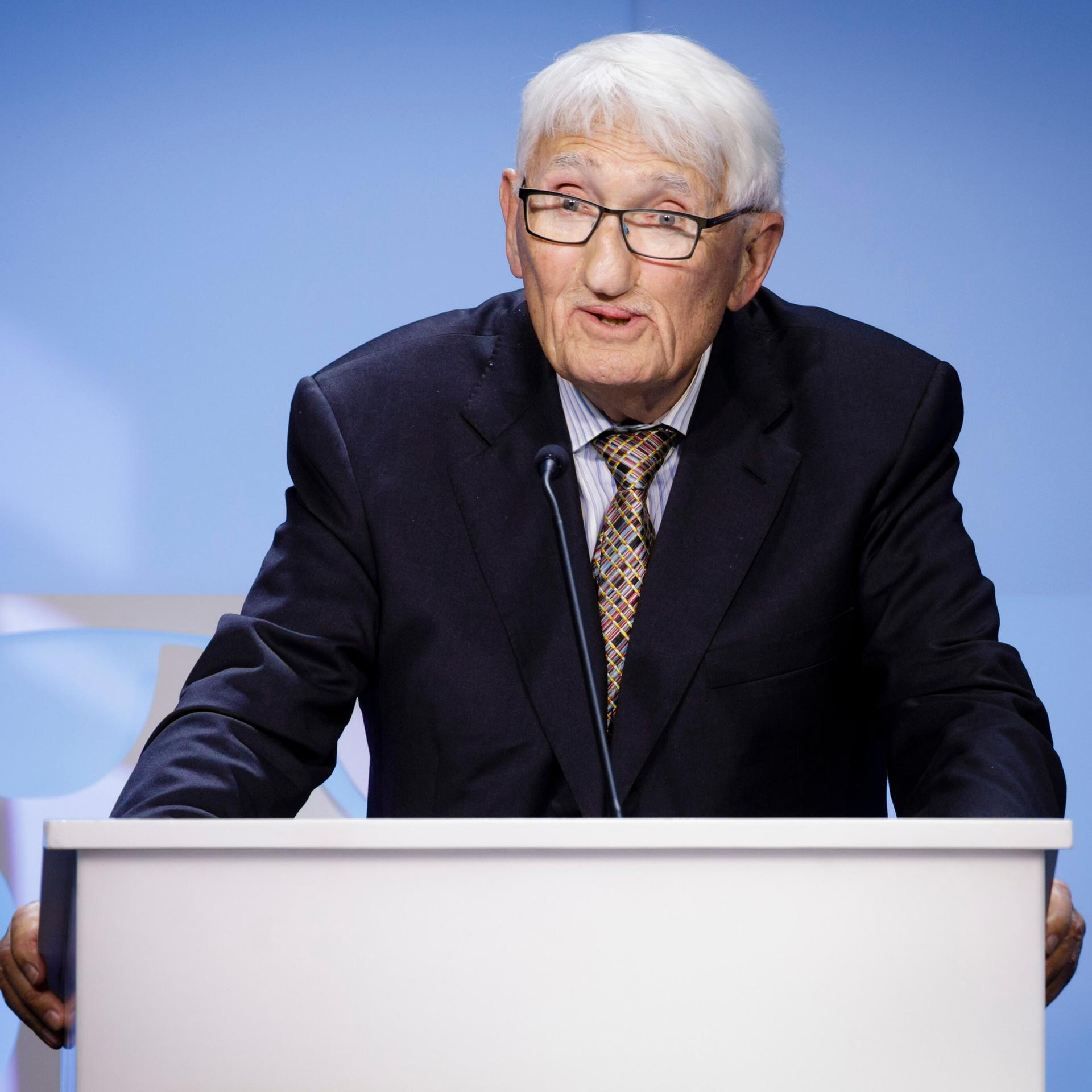 Der Soziologe und Philosoph Jürgen Habermas steht an einem Rednerpult und spricht zum Publikum.