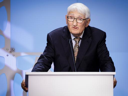 Der Soziologe und Philosoph Jürgen Habermas steht an einem Rednerpult und spricht zum Publikum.