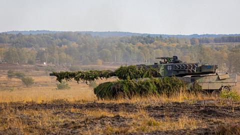 Ein Kampfpanzer der Bundeswehr vom Typ Leopard 2 fährt über einen Truppenübungsplatz.