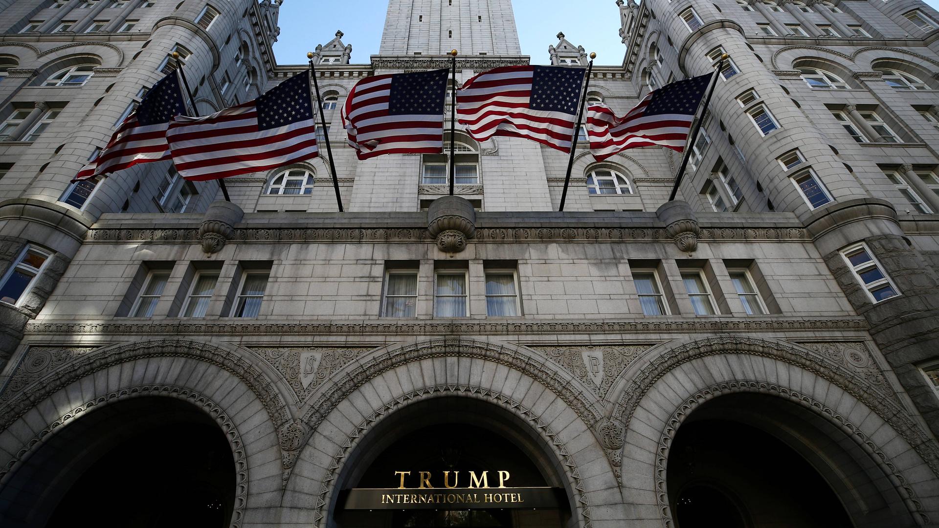 Das Trump Hotel im November 2020. Über dem mächtigen Portal wehen US-Flaggen. Das Hotel befindet sich in einem mächtigen Gebäude im neuromanischen Stil, das früher Hauptpostamt der USA war.