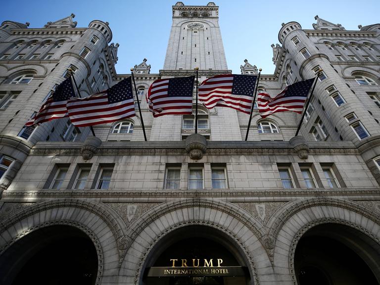 Das Trump Hotel im November 2020. Über dem mächtigen Portal wehen US-Flaggen. Das Hotel befindet sich in einem mächtigen Gebäude im neuromanischen Stil, das früher Hauptpostamt der USA war.