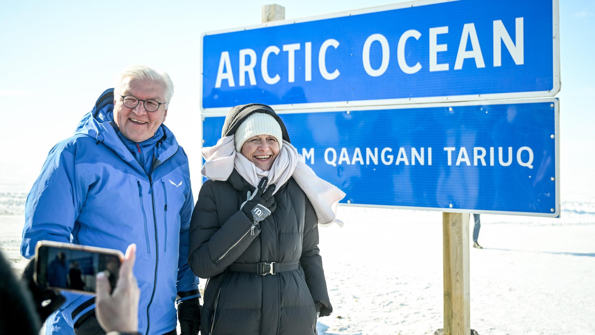 Bundespräsident Steinmeier und seine Frau Elke Büdenbender stehen in Anoraks in einer Schneelandschaft vor einem Schild mit der Aufschrift "Arctic Ocean".