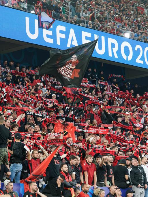 Albanische Fans halten während des EM-Spiels gegen Italien Schals hoch und schwenken Fahnen.