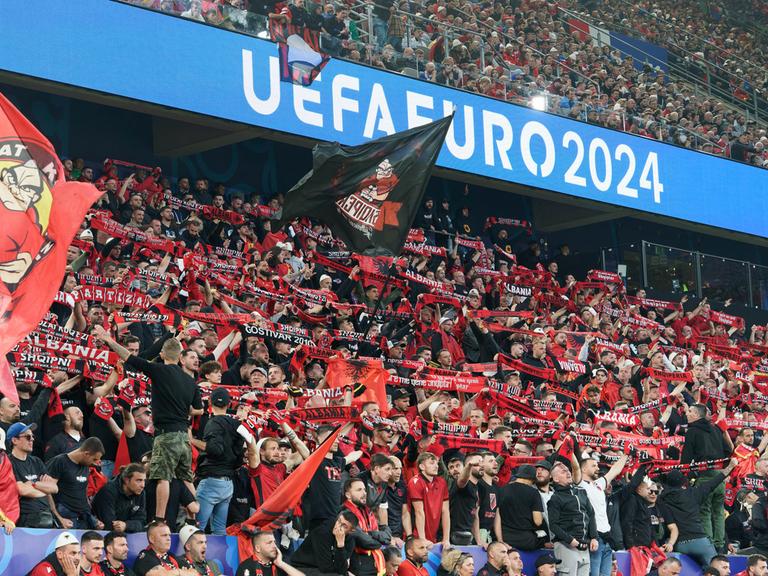 Albanische Fans halten während des EM-Spiels gegen Italien Schals hoch und schwenken Fahnen.