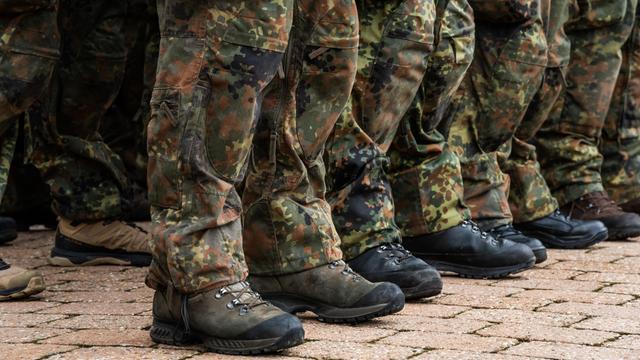 Zu sehen sind die Füße von Soldaten der Bundeswehr. Die Soldaten tragen Tarn-Uniform.