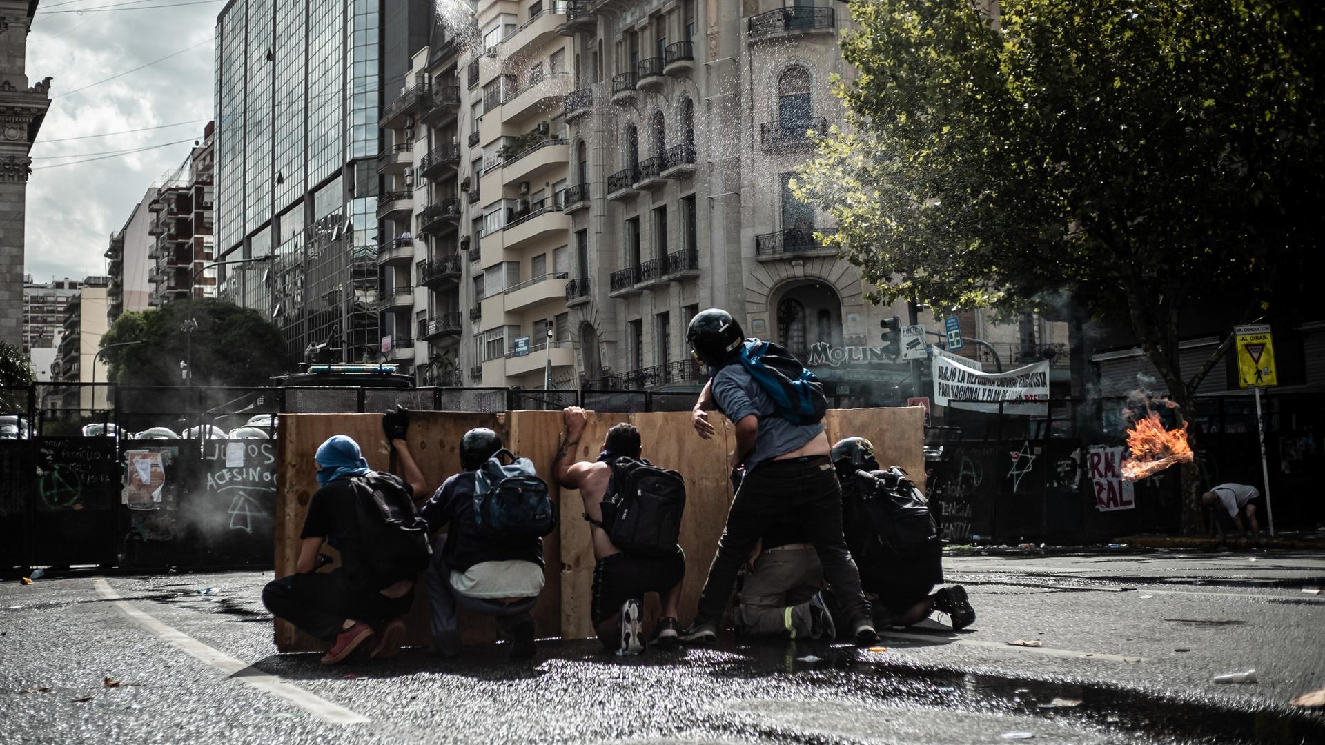 Während einer Demonstration von Gewerkschaften und Oppositionsanhängern gegen ein von der Regierung von Präsident Milei vorgeschlagenes Arbeitsreformgesetz gehen Demonstranten vor einer Straßensperre in Deckung. Während einer Demonstration von Gewerkschaften und Oppositionsanhängern gegen ein von der Regierung von Präsident Milei vorgeschlagenes Arbeitsreformgesetz gehen Demonstranten vor einer Straßensperre in Deckung.