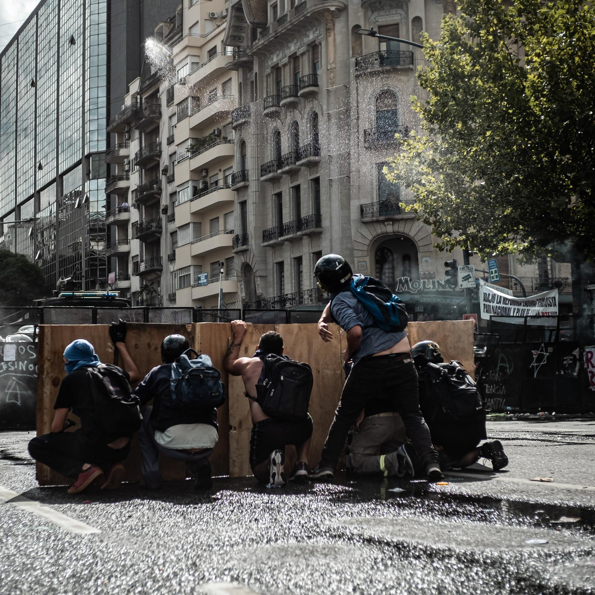Während einer Demonstration von Gewerkschaften und Oppositionsanhängern gegen ein von der Regierung von Präsident Milei vorgeschlagenes Arbeitsreformgesetz gehen Demonstranten vor einer Straßensperre in Deckung.