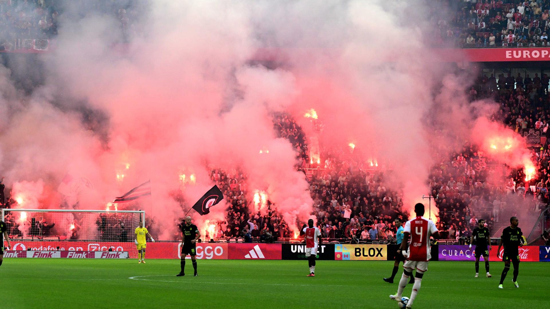 Das Foto zeigt eine Szene aus dem Fußballspiel Ajax Amsterdam gegen Feyenoord Rotterdam. Fans von Ajax Amsterdam zünden auf der Tribüne Pyrotechnik.