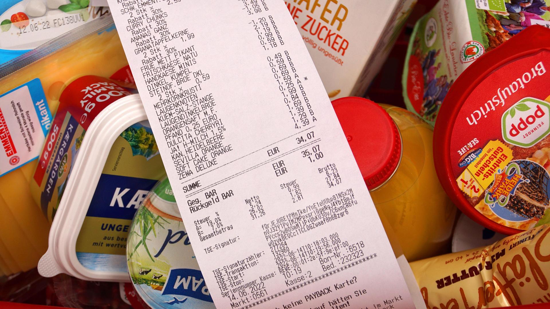In einem Einkaufskorb lieben viele Lebensmittel. Darauf liegt eine Quittung. In einem Einkaufskorb lieben viele Lebensmittel. Darauf liegt eine Quittung.