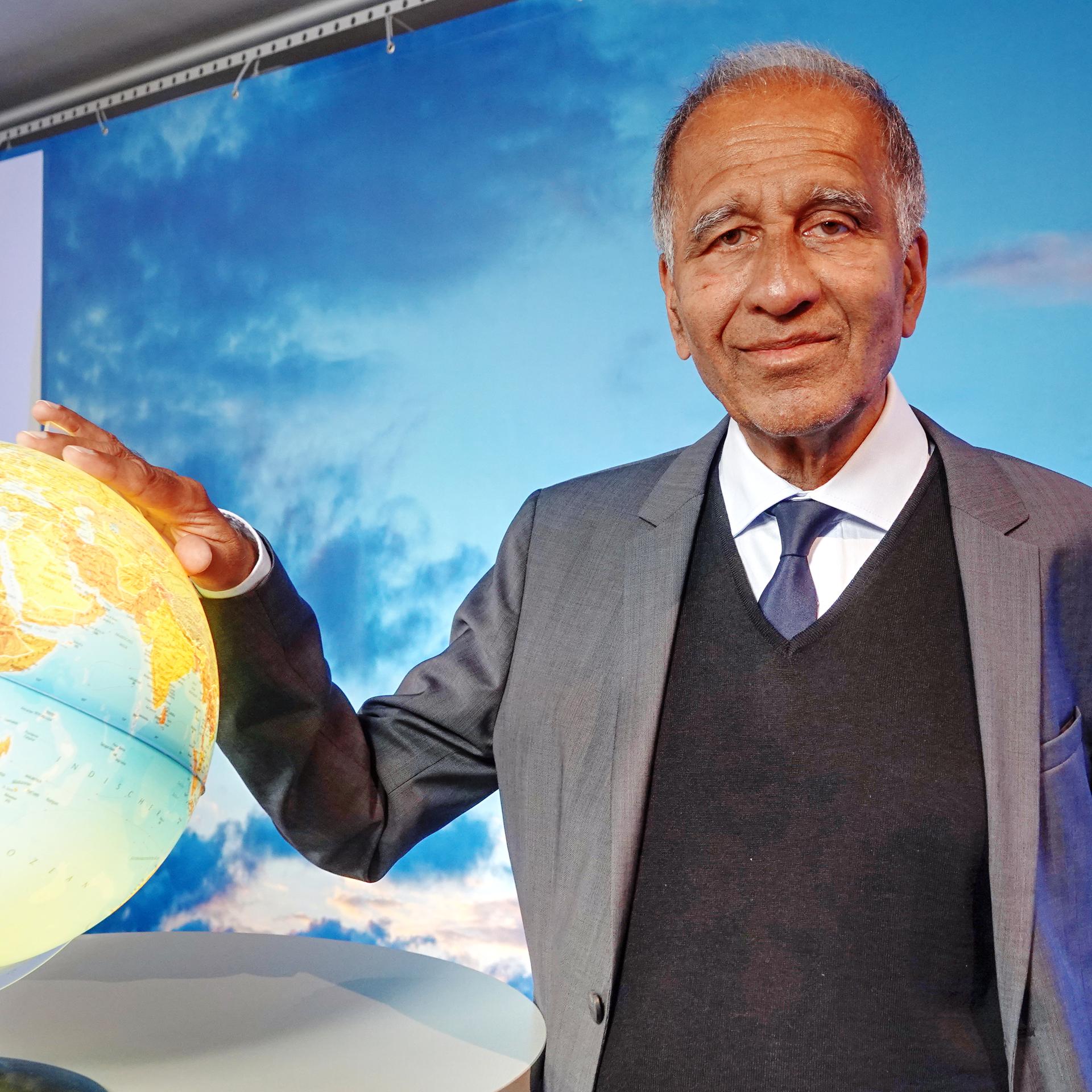 Mojib Latif, Klimaforscher, posiert bei dem 13. Extremwetterkongress im Internationalen Maritimen Museum Hamburg neben einem Globus.