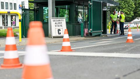 Sicherheitspersonal steht im Bereich der Einfahrt zur Nato Air Base, links der Hinweis auf den Security Alert State C.