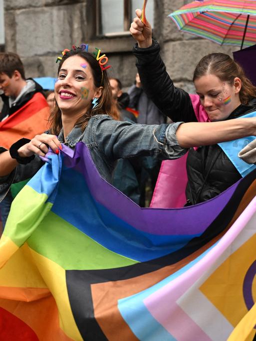 Feiernde bei der Europride-Parade in der serbischen Hauptstadt Belgrad schwenken eine Regenbogenflagge