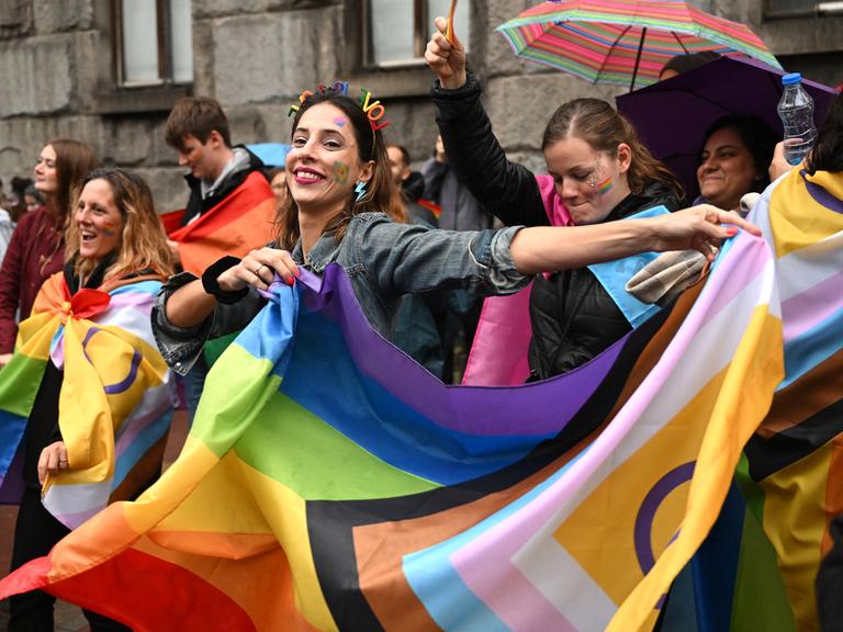 Feiernde bei der Europride-Parade in der serbischen Hauptstadt Belgrad schwenken eine Regenbogenflagge