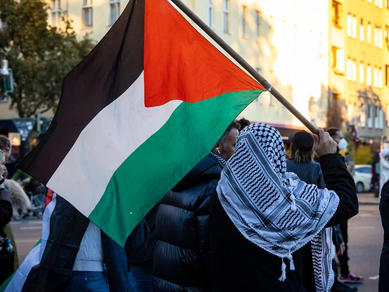 Ein Mann mit Palästinenser-Tuch und -Flagge auf einer Solidaritäts-Demonstration mit Palästina in Berlin Kreuzberg am 21. Oktober 2023.
