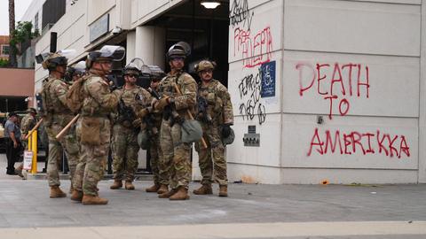 Einsatzkräfte der Nationalgarde stehen neben einem Gebäude, auf dem "Tod für Amerika" an die Wand geschmiert wurde.