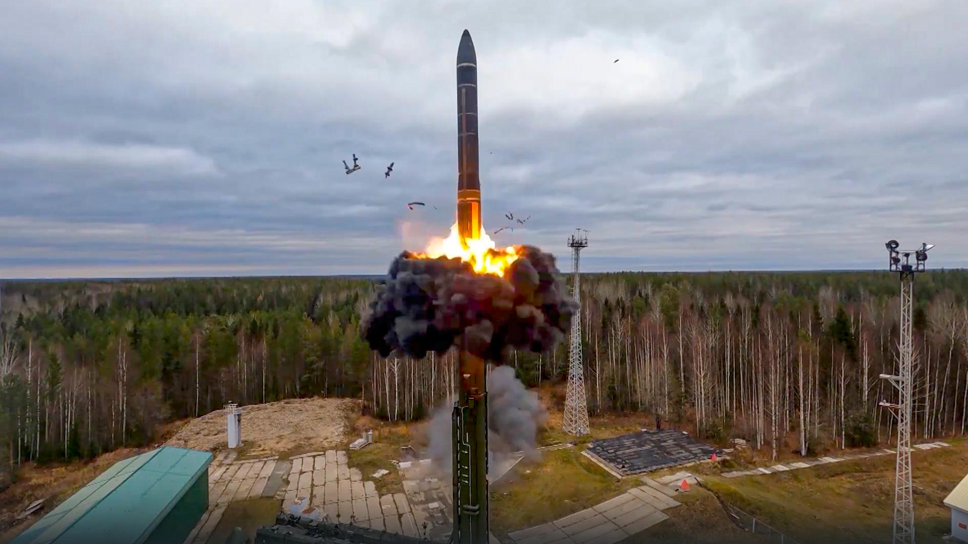 Eine Interkontinentalrakete wird von einem Startplatz in Russland abgefeuert. Sie hebt sich mit schwarzem Rauch und Feuerschweif in die Luft.