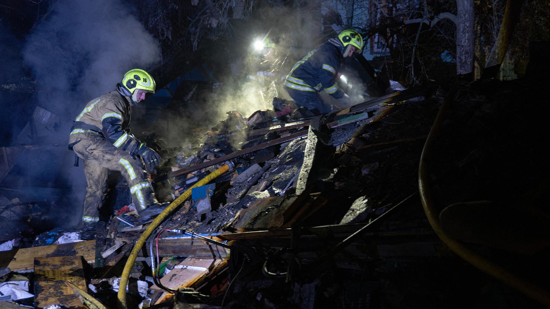 Ukrainische Feuerwehrleute durchsuche Trümmer eines Hauses nach einem russischen Raketenangriff in Kiew.