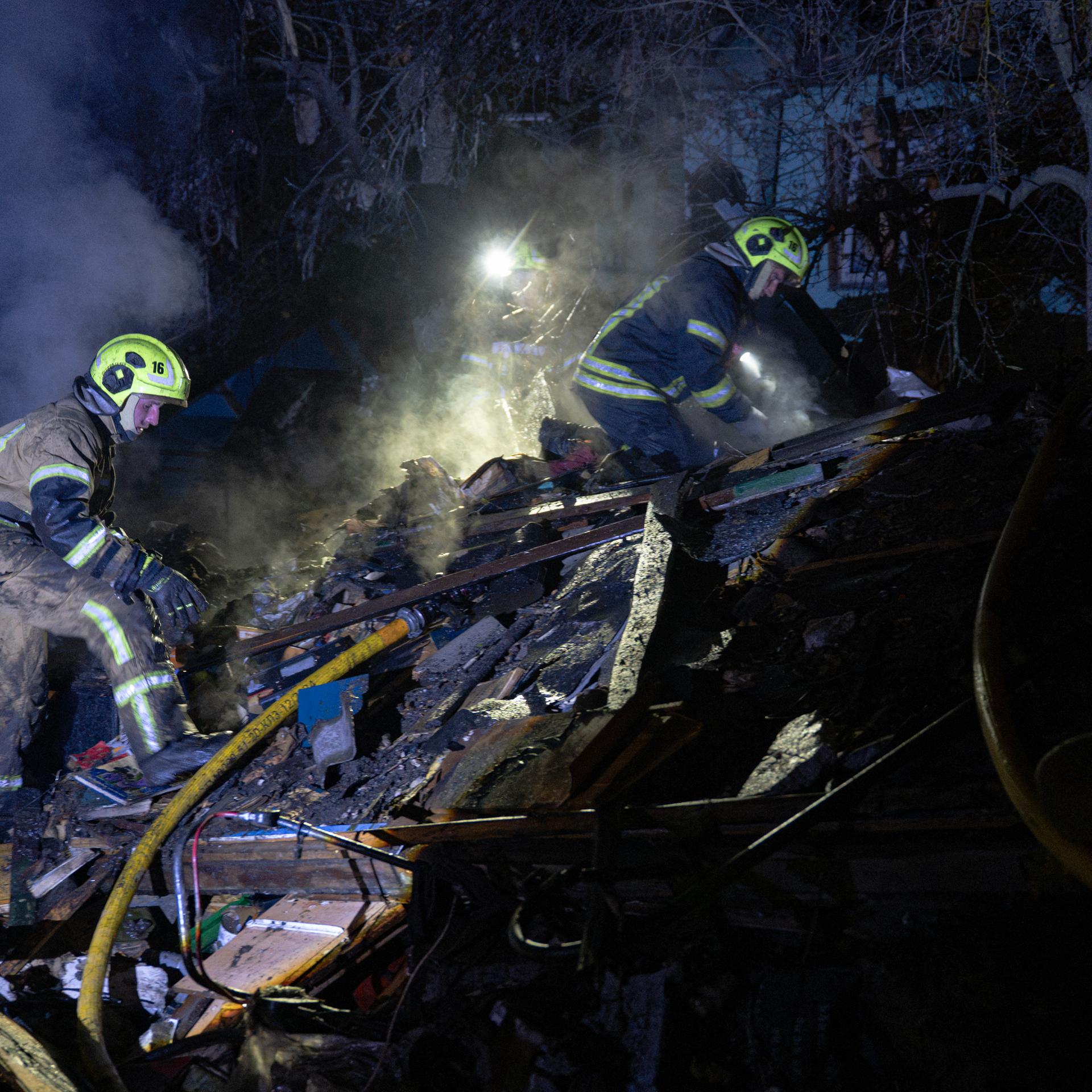 Ukrainische Feuerwehrleute durchsuche Trümmer eines Hauses nach einem russischen Raketenangriff in Kiew.