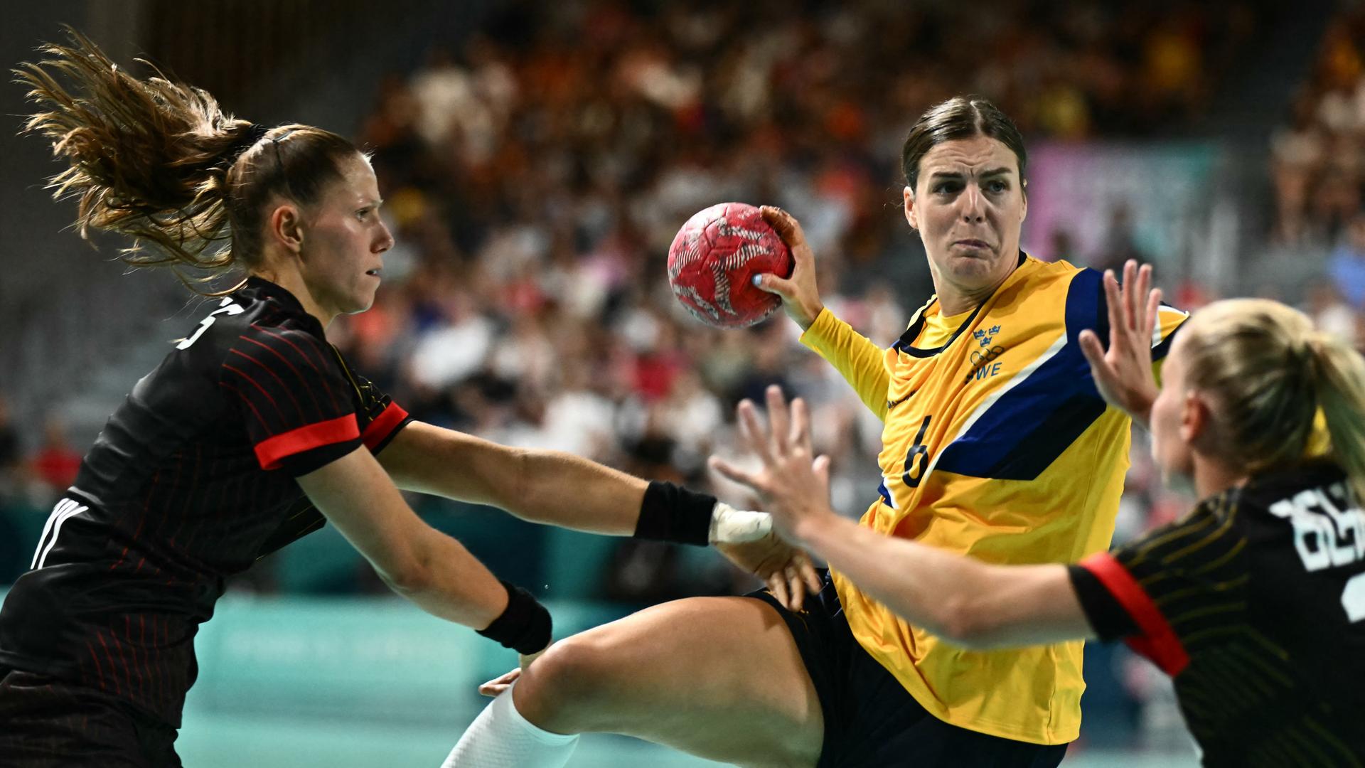 Das Bild zeigt die deutsche Handballerin Meike Schmelzer bei einem Angriff gegen das schwedische Team bei den Olympischen Spielen in Paris 2024. Das Bild zeigt die deutsche Handballerin Meike Schmelzer bei einem Angriff gegen das schwedische Team bei den Olympischen Spielen in Paris 2024.
