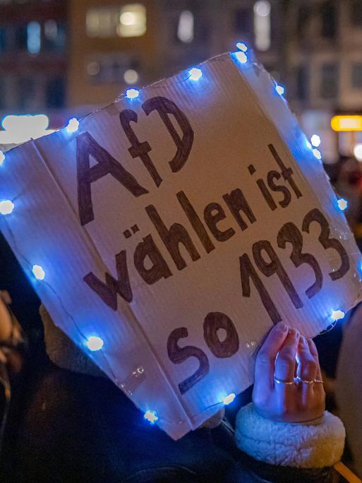 Bei der Demonstration gegen Rechts in Köln hält eine Demonstrantin ein Schild mit der Aufschrift "AfD wählen ist so 1933" in die Luft