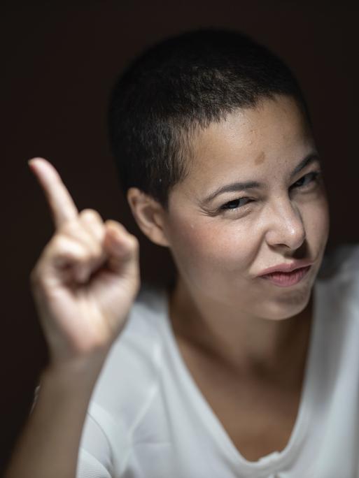 Eine Frau erhebt belehrend den Zeigefinger Eine Frau erhebt belehrend den Zeigefinger