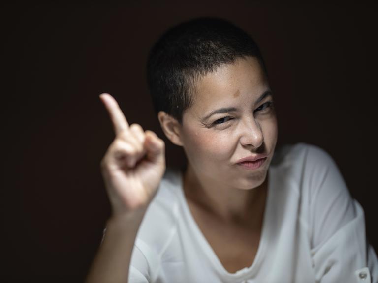 Eine Frau erhebt belehrend den Zeigefinger Eine Frau erhebt belehrend den Zeigefinger