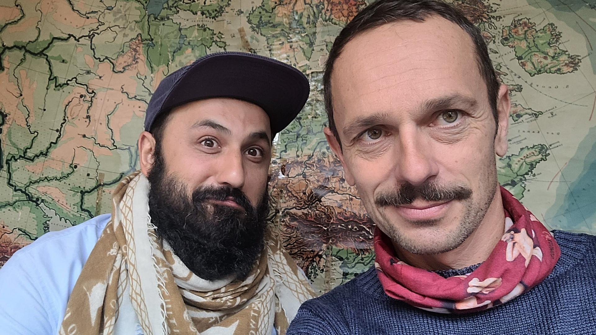 Selfie von Florian Schönhofer und dem Arzt Atal Rasoul vor einer Landkarte.