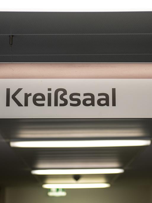 Das Schild "Kreißsaal" hängt in einem Flur eines Krankenhauses von der Decke.