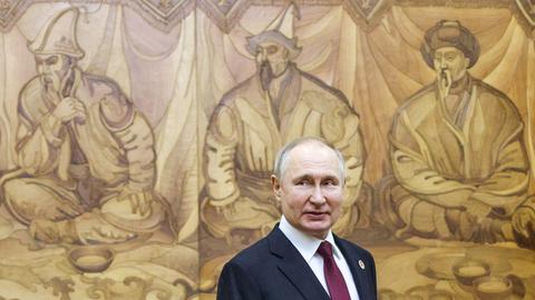 Russlands Präsident Wladimir Putin am Rande eines Treffens in Kirgistan im Dezember 2002. Im Hintergrund ein traditionelles Wandgemälde