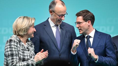 Bundeskanzler Friedrich Merz schaut den CDU-Spitzenkandidaten Manuel Hagel an, die spielerisch die Fäuste reckt. 