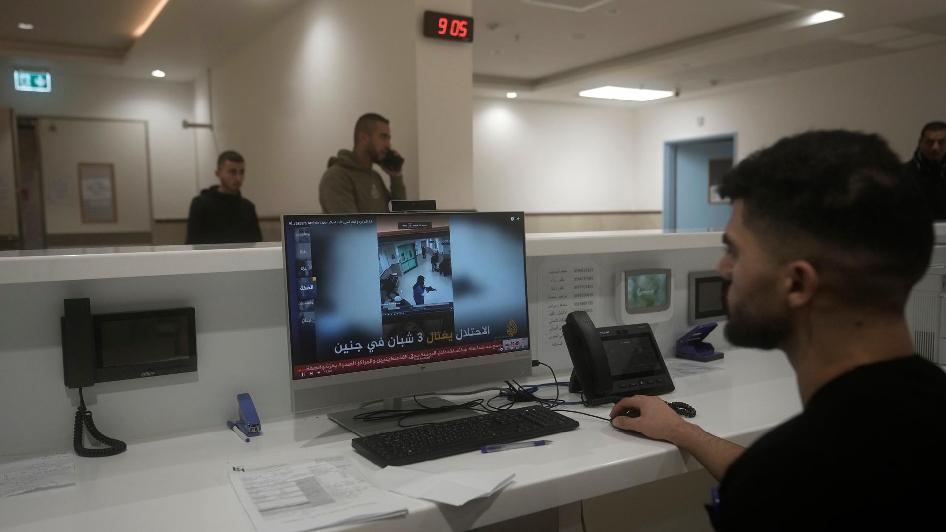 Palästinensische Gebiete, Dschenin: Ein Mitarbeiter des Ibn-Sina-Krankenhauses zeigt in einer Nachrichtensendung die Aufnahmen einer Sicherheitskamera, die einen israelischen Militärangriff zeigen.