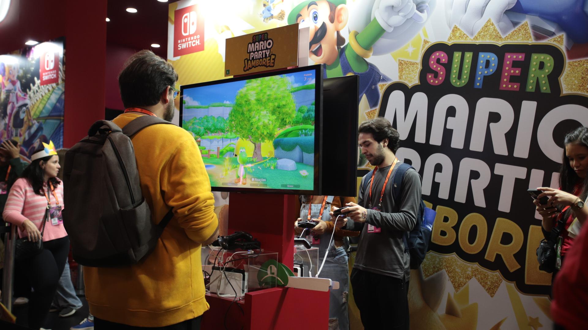 Ein Mann steht vor einem Bildschirm und spielt ein Super-Mario-Spiel von Nintendo