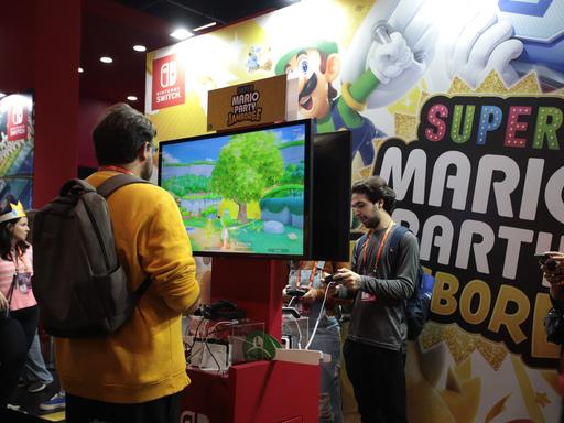 Ein Mann steht vor einem Bildschirm und spielt ein Super-Mario-Spiel von Nintendo