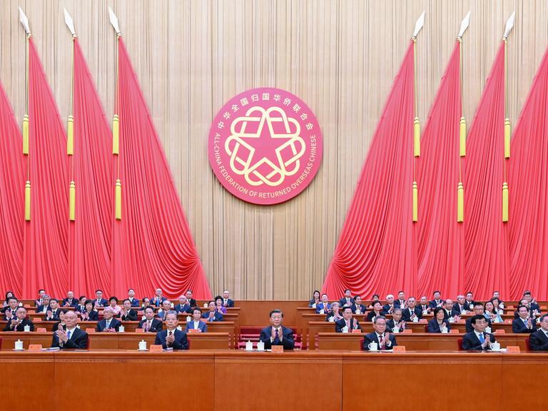Chinas Staatschef Xi Jinping bei einer Veranstaltung in Peking im August 2023 mit weiteren Staatsführern, im Hintergrund rote Flaggen.