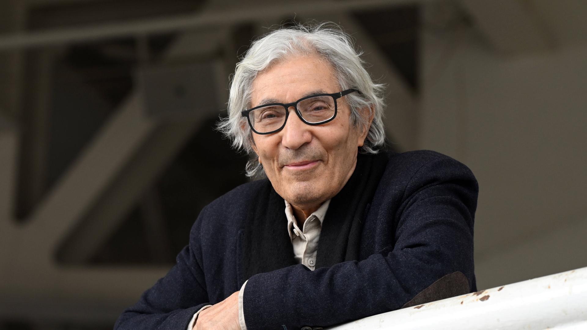 Der algerisch-französische Schriftsteller Boualem Sansal lehnt auf einem Geländer und schaut nach vorne