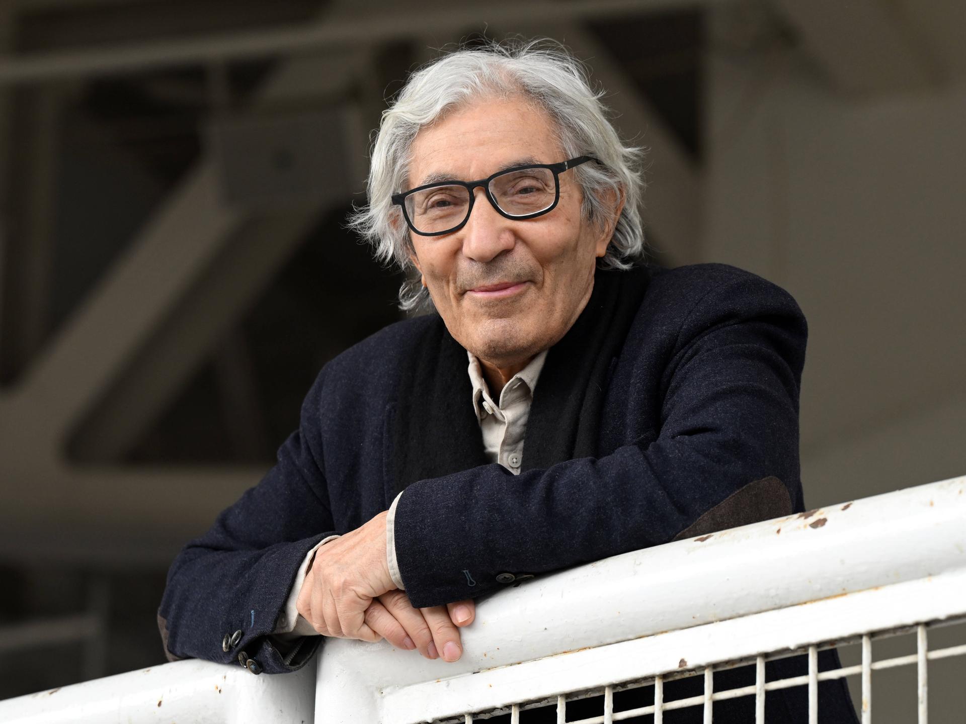Der algerisch-französische Schriftsteller Boualem Sansal lehnt auf einem Geländer und schaut nach vorne