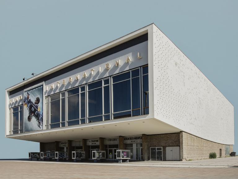 Die Fotografie der Künstlerin Sarah Eick zeigt das Berliner Kino International als Einzelgebäude vor einem blassblauen Hintergrund.