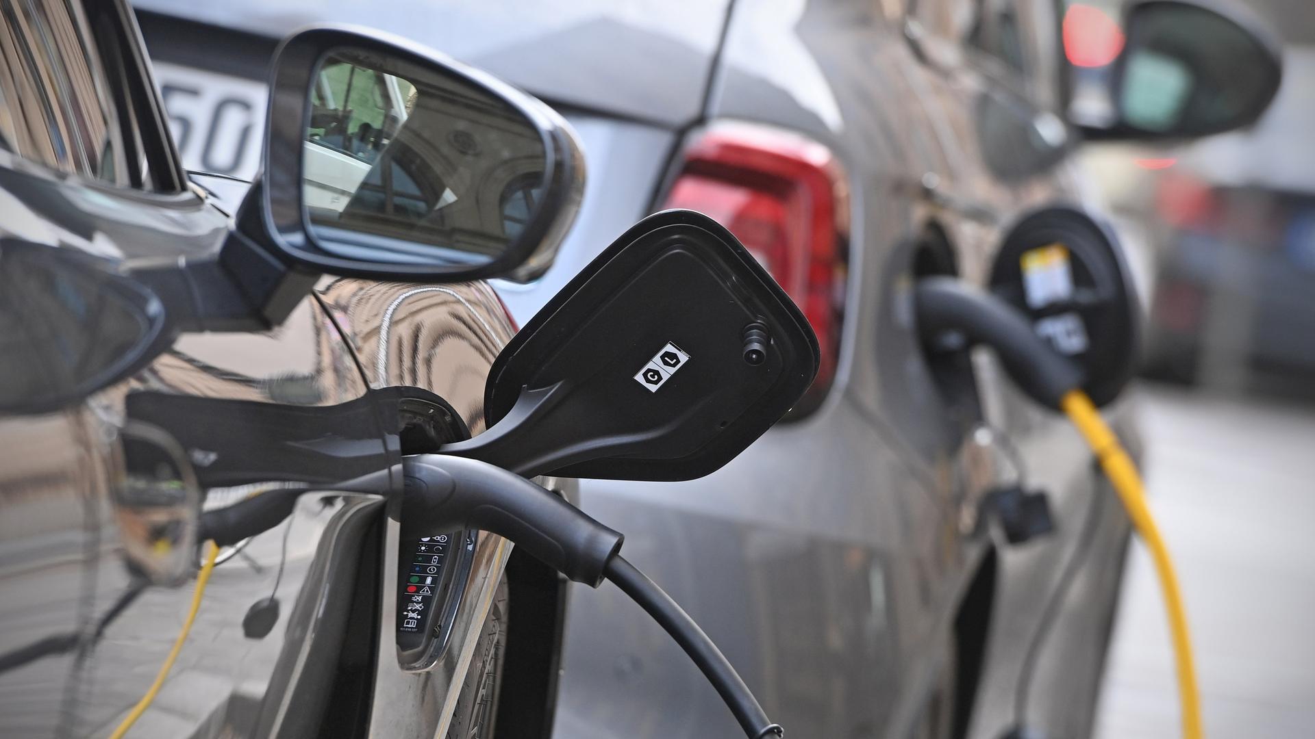 E-Auto am Strassenrand in Muenchen wird geladen, Stecker waehrend dem Ladevorgang an einem E-Auto