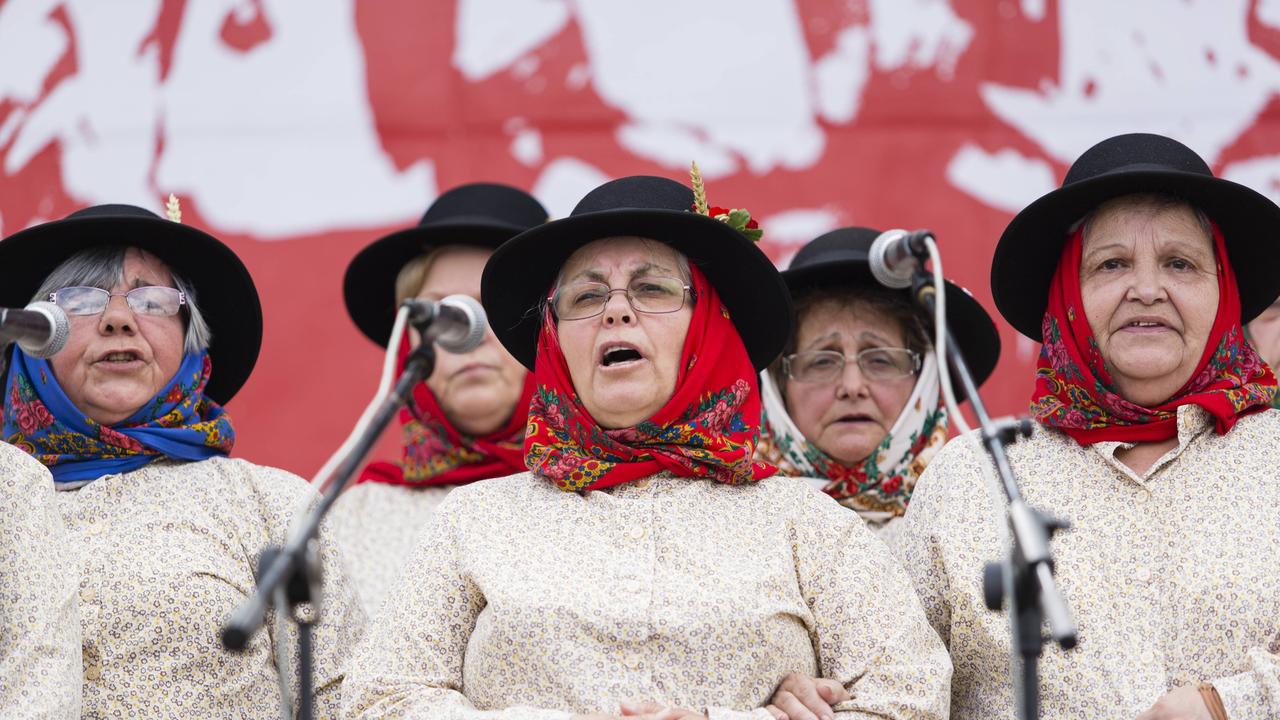 Sängerinnen eines Cante-Alentejano-Chors stehen mit untergehakten Armen vor Mikrofonen und singen. Der Cante Alentejano, der typische Gesang der Provinz Alentejo im Süden Portugals, zählt seit 2014 zum immateriellen UNESCO Weltkulturerbe.
