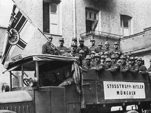 Schwarzweißfoto eines Stoßtrupps auf einer Lkw-Ladefläche, aufgenommen im November 1923, zur Zeit von Adolf Hitlers Putschversuch im Münchner Bürgerbräukeller