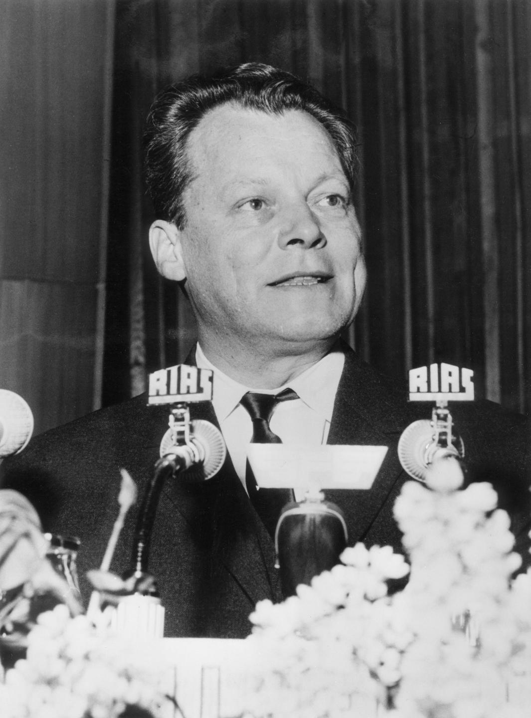 Willy Brandt 1961. Ein Mann steht vor einem Mikrofon.