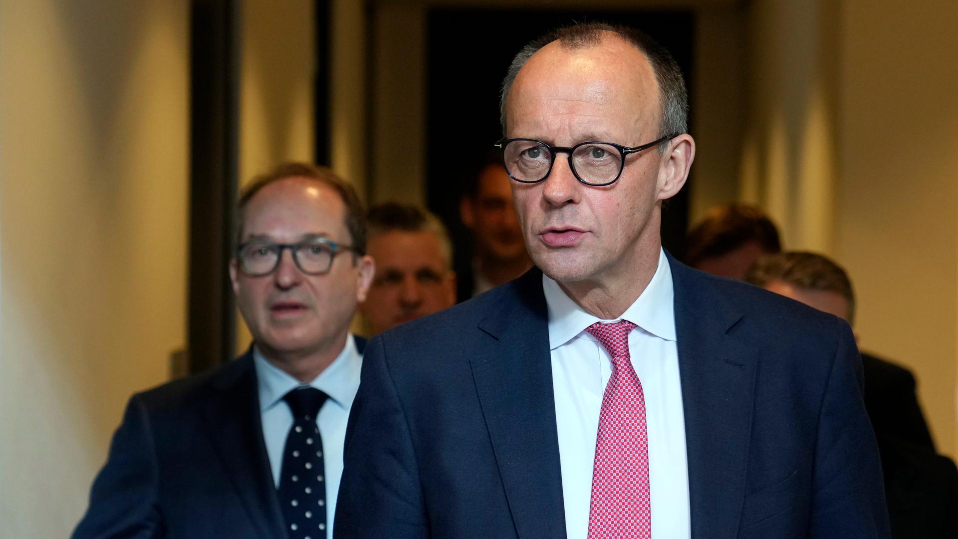 Friedrich Merz läuft von seinem Büro im Deutschen Bundestag zu einem Fraktionstreffen, dahinter Alexander Dobrindt.